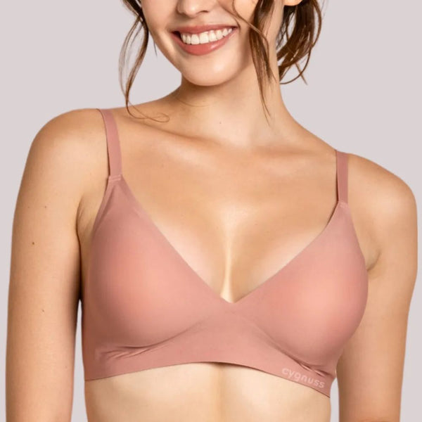 Modelo sorridente vestindo o Sutiã Model Sem Aro Cygnuss na cor rose. A peça possui tecido macio, alças finas ajustáveis e modelagem sem costura para um caimento natural e confortável.