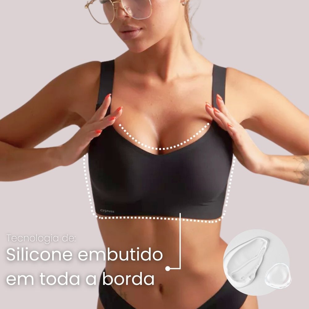 Imagem em close do Sutiã Premium Reforçado Cygnuss na cor bege, com modelo segurando o tecido para demonstrar a suavidade e elasticidade do material.