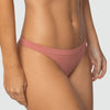 Close frontal da calcinha fio rosé Cygnuss x Lupo, vestida por modelo real. Com laterais médias e acabamento sem costura, a peça em microfibra oferece toque macio, ajuste perfeito e conforto invisível sob a roupa.