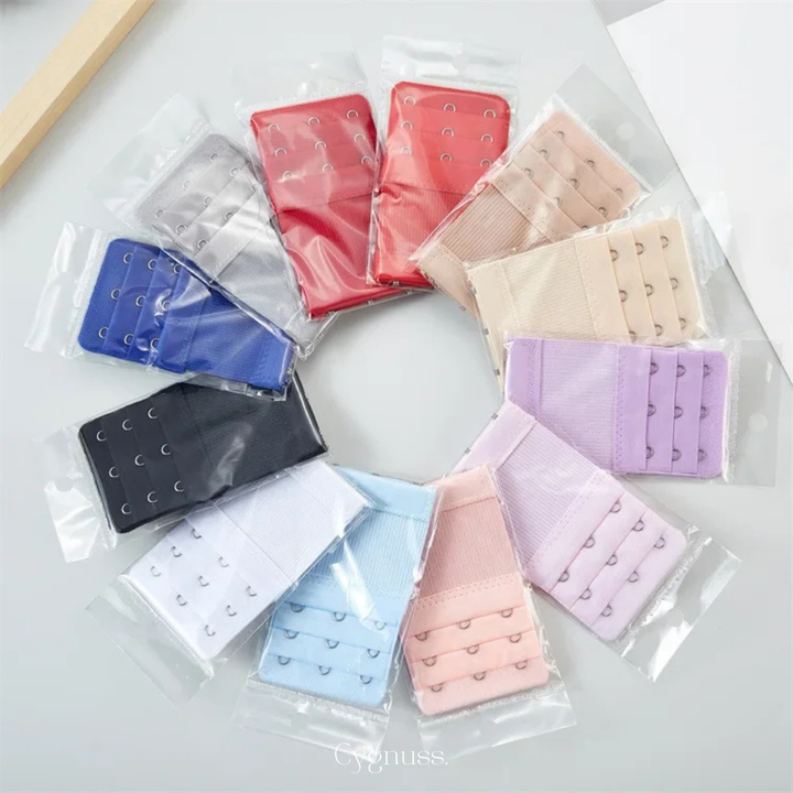 Conjunto de extensores de sutiã em diferentes cores, organizados em círculo. Cada acessório possui três níveis de ajuste e ganchos metálicos, ideais para aumentar o conforto e prolongar o uso do sutiã. Embalados individualmente e compatíveis com a maioria dos modelos.