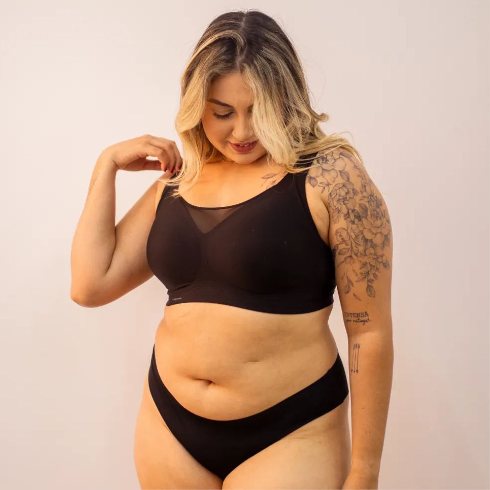 Mulher com corpo real usando o sutiã preto da Cygnuss, exibindo o design confortável com detalhe em tule no decote e modelagem que valoriza as curvas naturais.