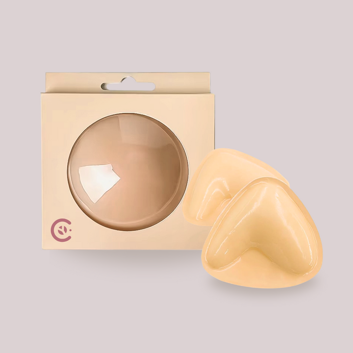 Protetor de silicone Perfect Up da Cygnuss com efeito lifting, em formato anatômico, acompanhado de embalagem bege com visor redondo. Ideal para usar com roupas decotadas ou sem alças, oferecendo sustentação e efeito up de forma discreta e confortável.