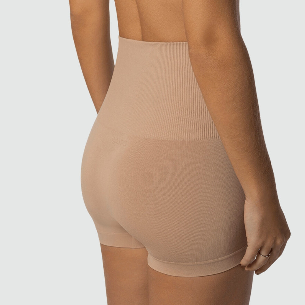 Vista traseira lateral do Short Slim Modelador Cygnuss x Lupo na cor bege, evidenciando a modelagem que realça os glúteos, a cintura alta e o tecido com compressão suave e acabamento sem costuras.