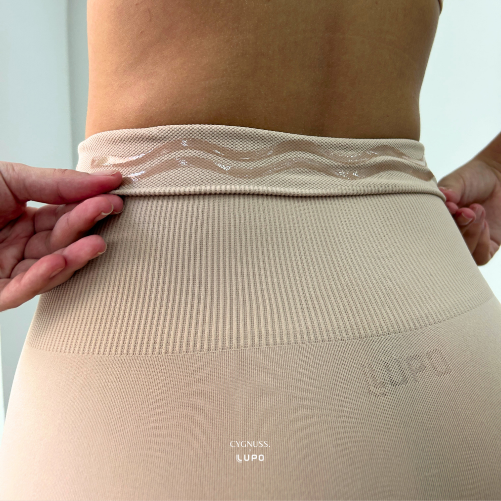 Close-up da parte traseira do Short Slim Modelador Cygnuss x Lupo na cor bege, mostrando o detalhe interno em silicone na cintura, que garante maior fixação e segurança durante o uso.

