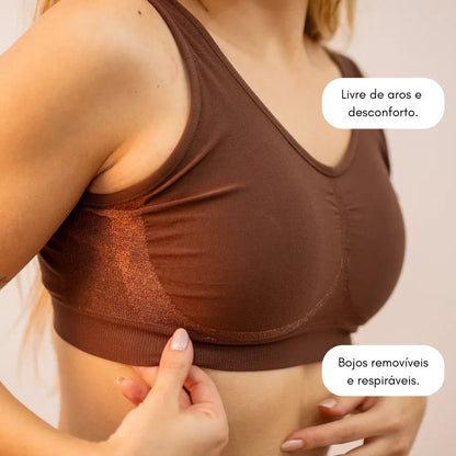  Mulher ajustando o bojo removível do Sutiã Daily Original na cor marrom. Destaque para a ausência de aro e conforto do modelo.