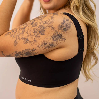 Mulher vestindo o sutiã preto Cygnuss, destacando o design sem costuras, alças largas e o detalhe em tule no decote para um toque moderno e sofisticado.