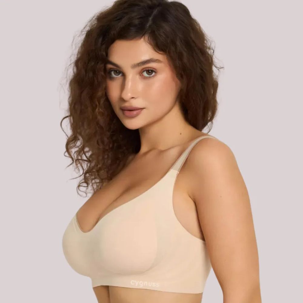Imagem de uma modelo vestindo o Sutiã Daily Original Cygnuss na cor bege. O design sem costuras proporciona um ajuste suave ao corpo, garantindo conforto absoluto. As alças finas e estruturadas complementam a sustentação sem comprometer a leveza do tecido. Ideal para quem busca elegância e comodidade no dia a dia.