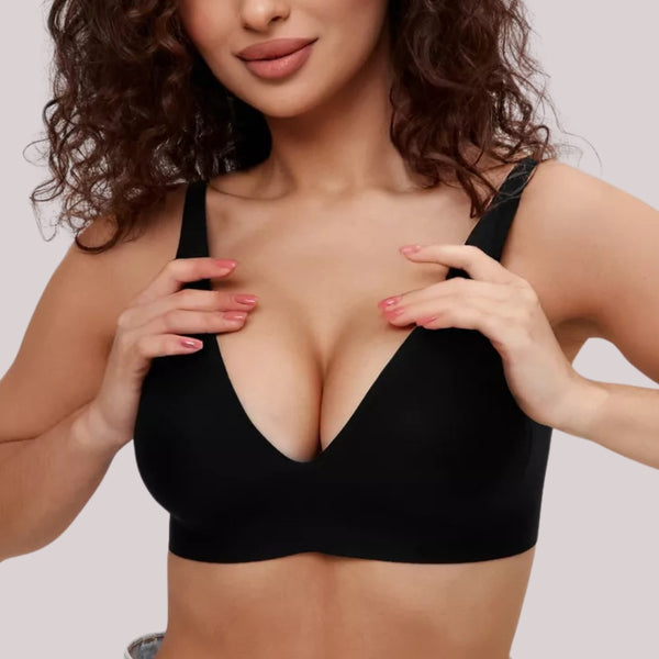 Mulher vestindo o Sutiã FIT da Cygnuss na cor preta, com alças finas e bojo removível. A imagem frontal destaca o decote profundo em V, o ajuste perfeito e o toque moderno e minimalista da peça, ideal para valorizar o busto com leveza e conforto.