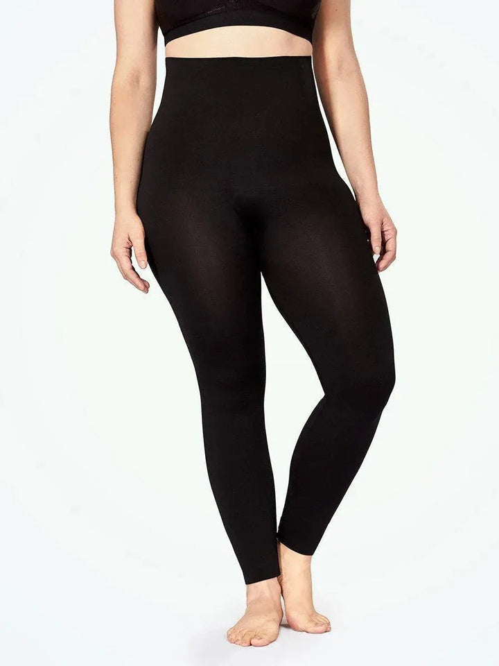 Imagem frontal da Legging Jade Fit Modeladora de Cós Alto na cor preta, com foco no caimento da peça no corpo, mostrando a modelagem ajustada, o comprimento até o tornozelo e o cós alto que cobre toda a região abdominal.